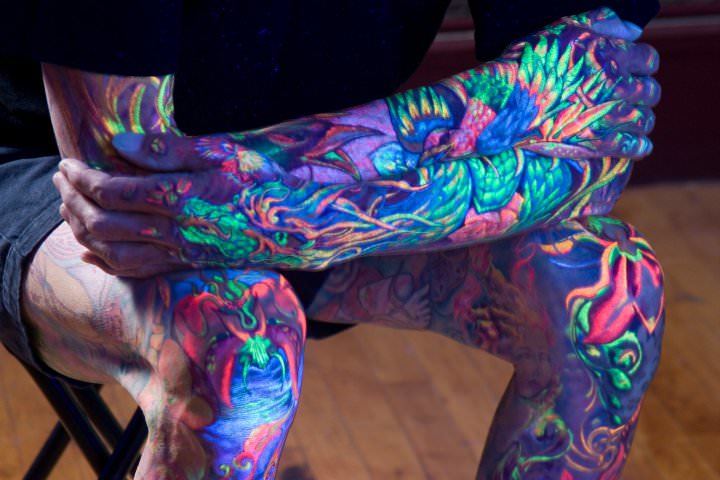 When seen under a blacklight, Glowrious Georges tattoos come alive with a UV glow