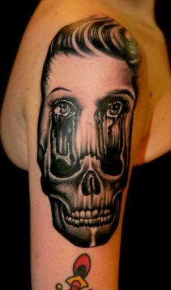 A woman's face melts into an image of a skull in this psychological portrait tattoo by Pietro Sedda