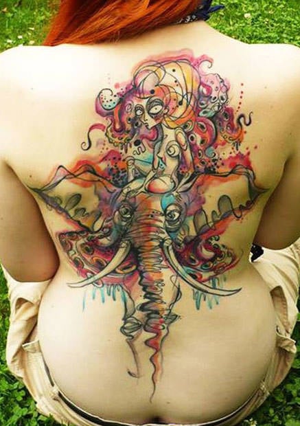 Petra gives this watercolor tattoo of a woman sitting on an elephant an ecclectic and artistic appeal