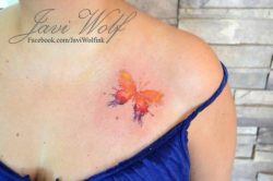 A simple butterfly becomes a beautiful art work in this colorful watercolor tattoo by Javi Wolf