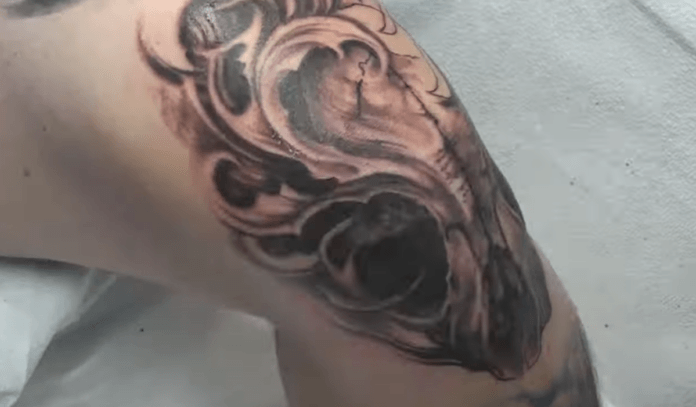 Jeremiah Barba used black, red, white and yellow tattoo inks to give this flame demon skull extra depth and perspective. At this point in the tattoo process, the skull tattoo already has some shading with black and red inks. [Still frame from the YouTube tattoo video]