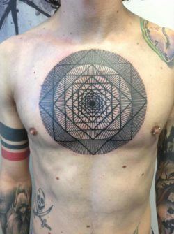 Repetitive lines and geometric shapes become a trippy mandala tattoo by Pierluigi Deliperi