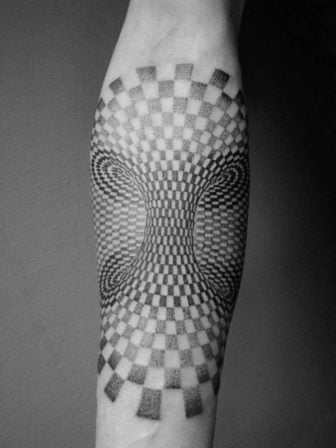Tattoo artist Deliperi creates a mind blowing optical illusion tattoo by simply warping a checker board