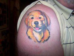 A golden retriever puppy grins out of this cute tattoo celebrating a favorite pet