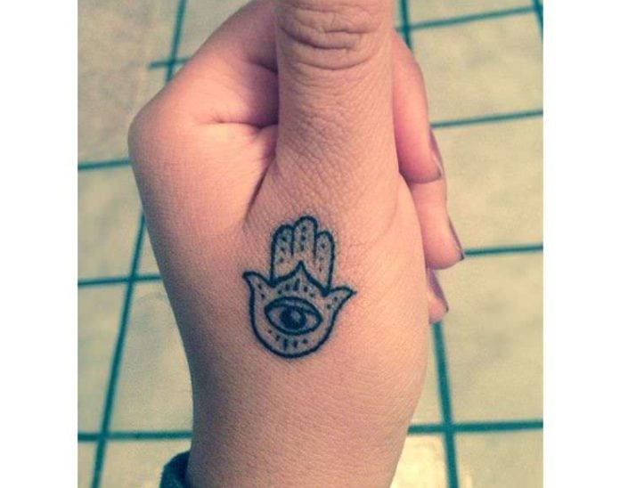 A tiny Hamsa tattoo below the thumb ensures that its wearer will always be able to see it and admire it