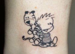 Calvin carries his friend Hobbes in this cute tattoo that represents friendship and innocence