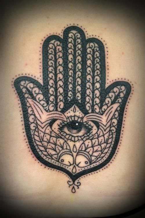 This Hamsa hand tattoo includes fish as symbols of abundance