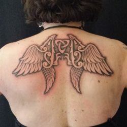 A celtic knot is at the heart of this wings tattoo across the shoulders - by Art on the Body tattoo studio