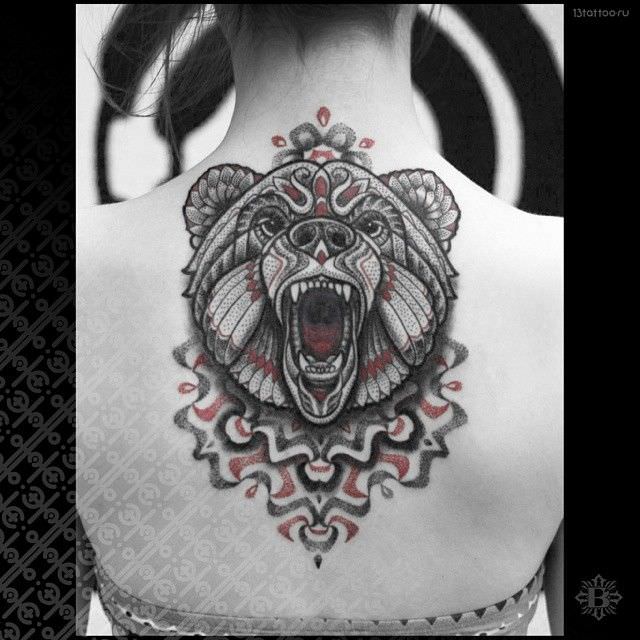 A roaring bear leaps from the center of the mandala that is the base of this tattoo design