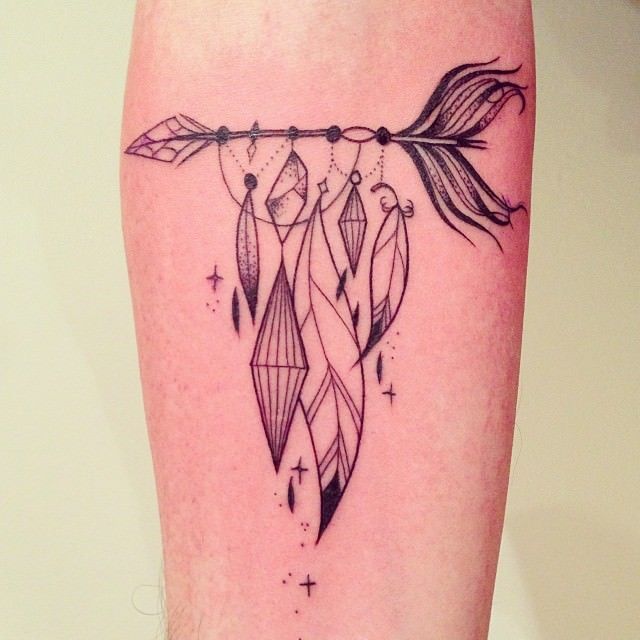 An arrow carries symbols of freedom, wisdom and dreams in this elegantly simple tattoo by Supakitch