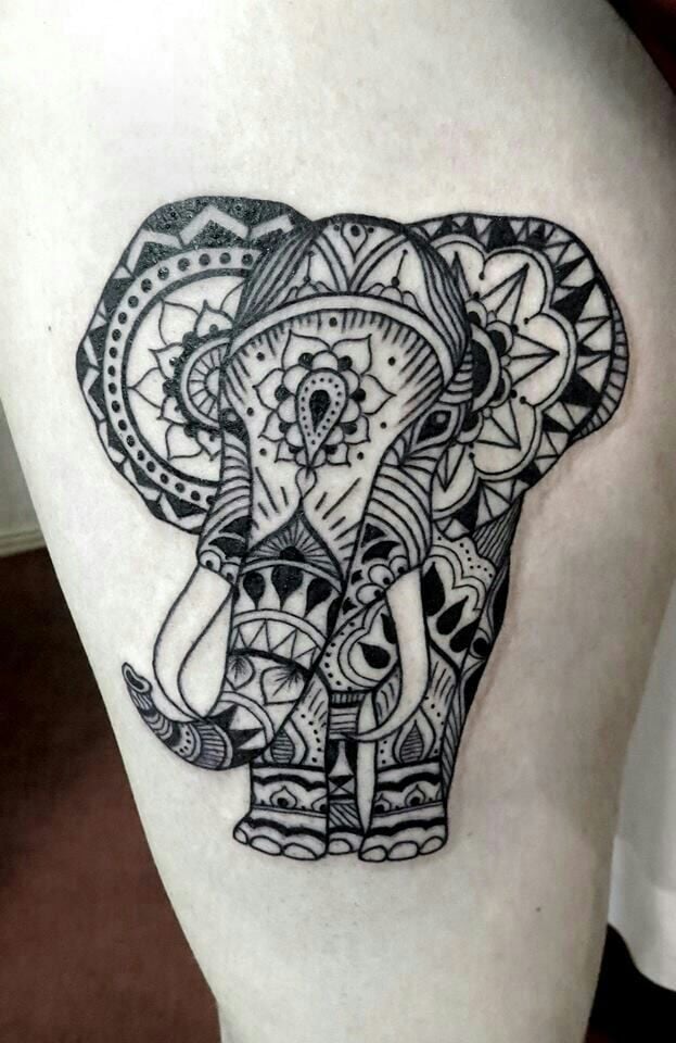 This spiritual tattoo has an elephant wearing mandala patterns all over its body