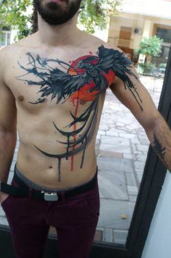Greek tattoo artist Dynoz inked this incredible watercolor tattoo of a phoenix rising from the ashes in front of a blazing hot sun