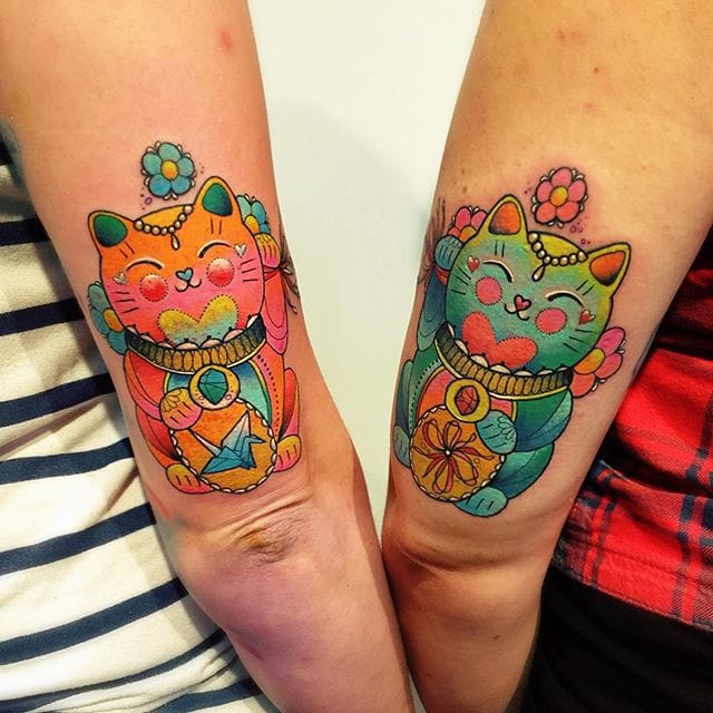 Maneki-neko (Chinese luck cats) feature in this watercolor friendship tattoo by Katie Shocrylas