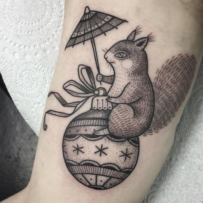 Suflanda tattoos a dotwork design of a squirrel sitting on a Christmas ornament while holding a cocktail umbrella