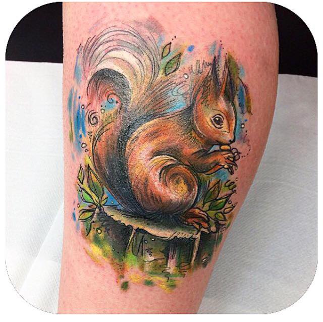 Tattoo artist Angharad Chappelle combines watercolour and sketch styles for this colourful tattoo of a squirrel eating a nut