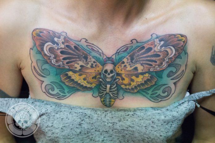 The Death's hawk moth tattoo by Ben Shaw features a human skull nestled between the moth's wings which fit perfectly on this girl's chest.