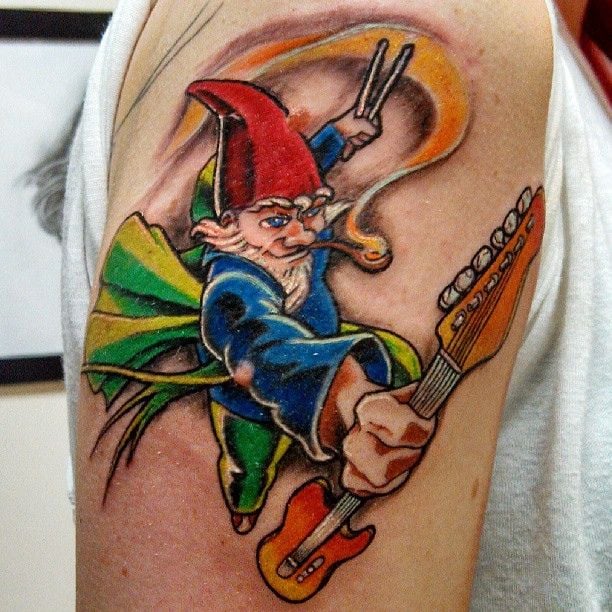 A gnome musician charges with his guitar in this musical tattoo