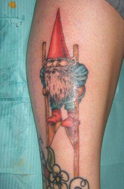 A gnome uses stilts to make himself taller in this cute and fun tattoo