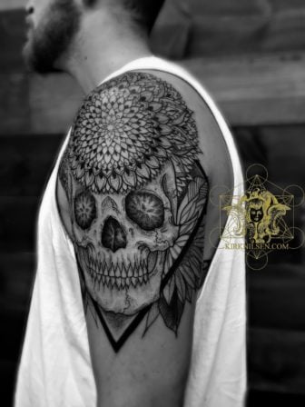 Life and death are balanced in this black ink tattoo by master tattooist Kirk Nilsen