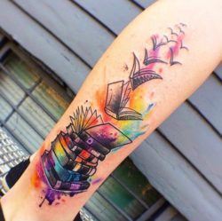 A pile of books takes flight as it transforms into a flock of birds in this colorful book tattoo for nature lovers