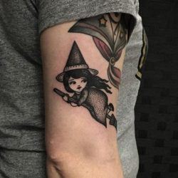 A cute witch peeks over her shoulder in this adorable tattoo by Sarah Whitehouse
