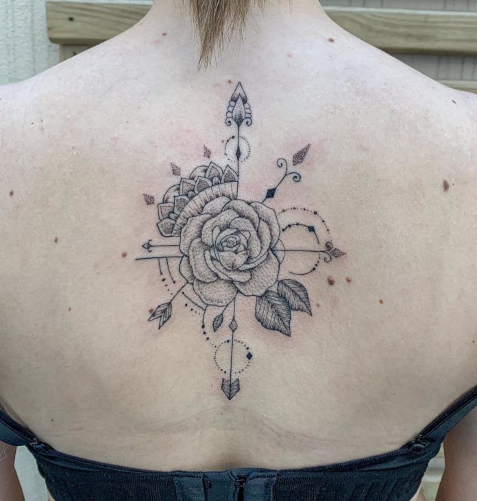 This stunning back tattoo by José Flávio Audi uses the symbols of a rose, compass points, leaves, mandala petals and jeweled ornaments