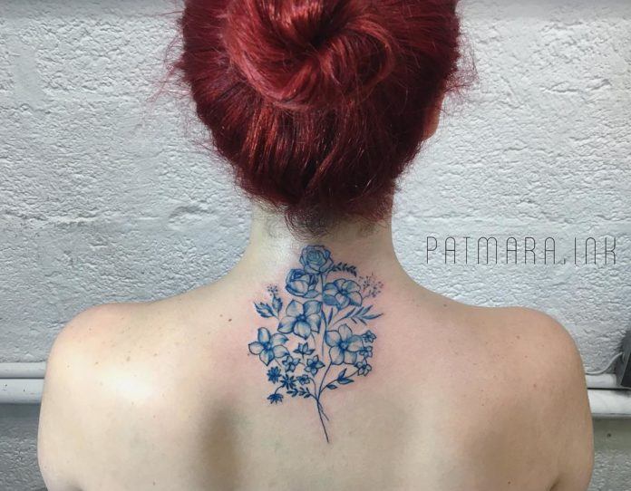 A small spray of wildflowers and foliage are the subject of this feminine neck tattoo by Patrícia Mara