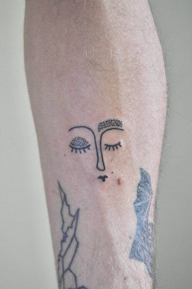 This abstract portrait tattoo uses dotwork to shade the eyelid and eyebrow of the sleeping woman