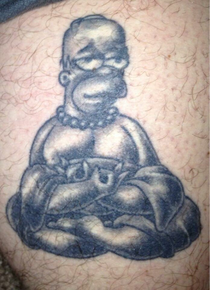 Homer Simpson sits in the Lotus Position meditation pose in this funny tattoo dedicated to the spiritual practice of meditating