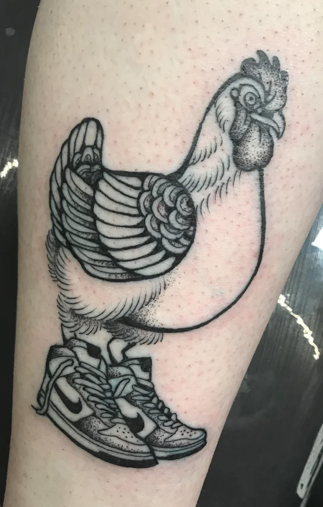 A chicken wears Nike trainers in this black ink linework tattoo by Stephanie Manca 