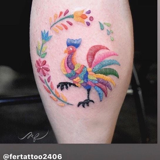 Talented tattoo artist Fernanda Ramirez has inked this embroidered tattoo of a colourful chicken on her happy client. The tattooist has realistically depicted the individual threads of the embroidered design by using lighter and darker inks to create highlights and shadows, giving the tattoo textures and depth. The style of the design is reminiscent of Hungarian floral embroidery.