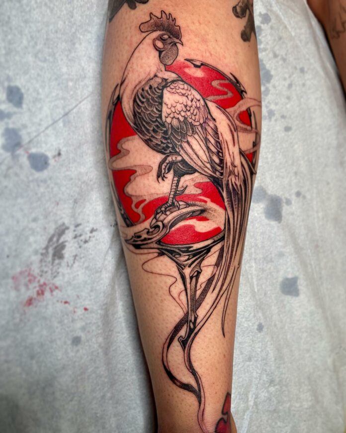Tattoo artist Sal Tino has used a fantasy illustration style give this rooster tattoo a beautiful, dark mystique. The black ink rooster figure poses against a magical orb in the background, which the artist has chosen to colour with a vibrant and alarming shade of red tattoo ink. The tattooist has used tiny dots of ink to give the shaded areas texture as added visual appeal.
